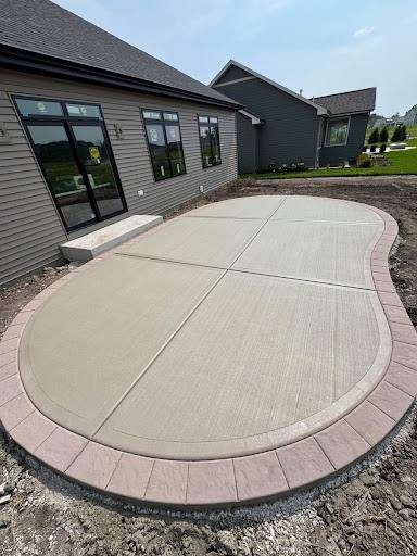 Finished curved concrete patio with a paver border.