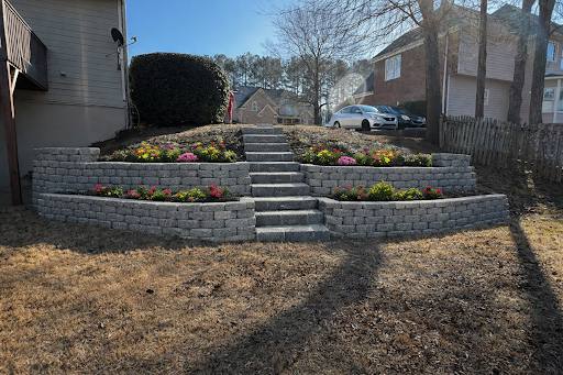 Multi-tiered stone retaining wall with planted beds and steps.